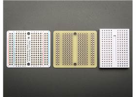 Top and bottom view of the Adafruit Perma-Proto Quarter-Sized Breadboard PCB next to a standard 170-point breadboard