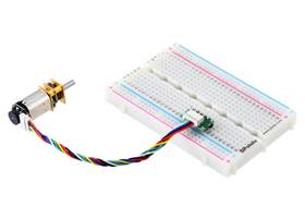 Side-entry JST SH-style connector breakout board in a breadboard, female-female cable, and encoder with connector mounted on a Micro Metal Gearmotor.