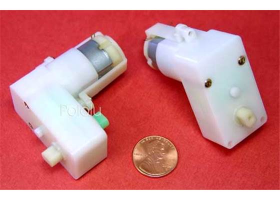 Solarbotics GM8 gearmotor with offset shaft , two pieces next to penny.