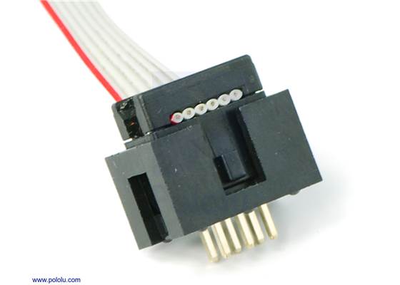 Shrouded 2&#215;3-pin box header with a ribbon cable and IDC connector plugged into it.