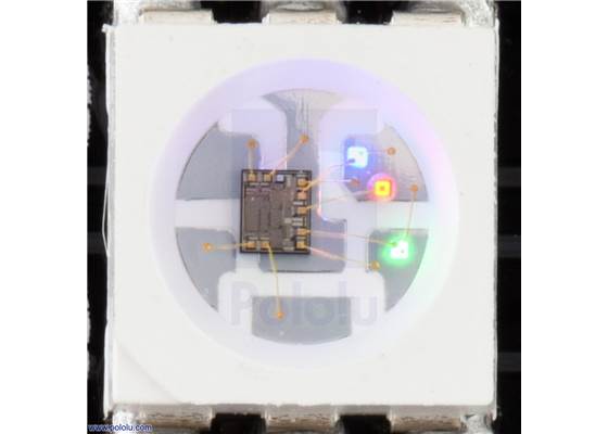 Close up of an APA102C, with the red, green, and blue LEDs on at a low brightness.